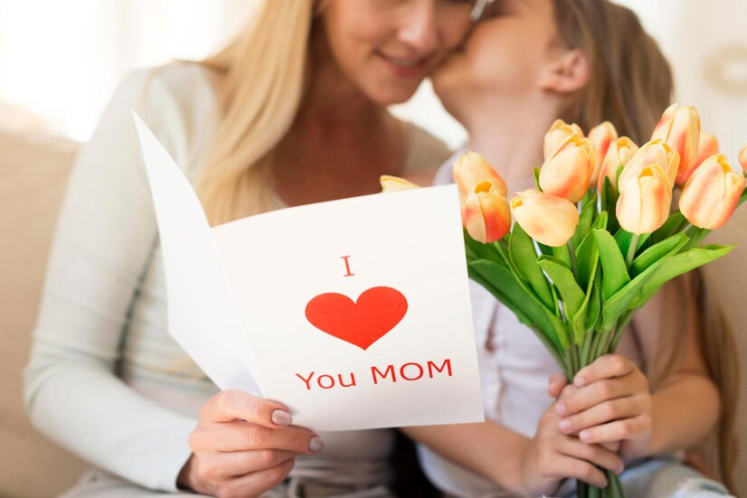 fille faisant bisous à sa mère avec une carte de citations maman